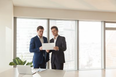 Two serious businessmen discussing building plan, construction i high lending ratios
